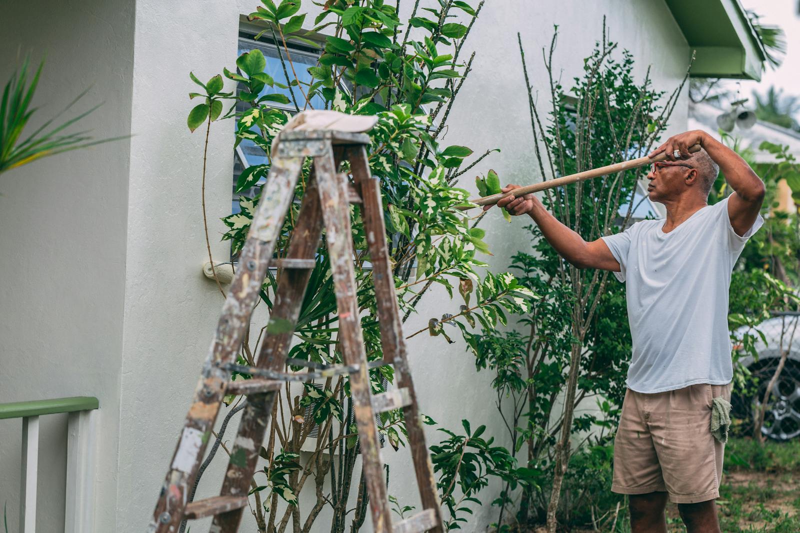 Painter applying exterior paint to a house wall